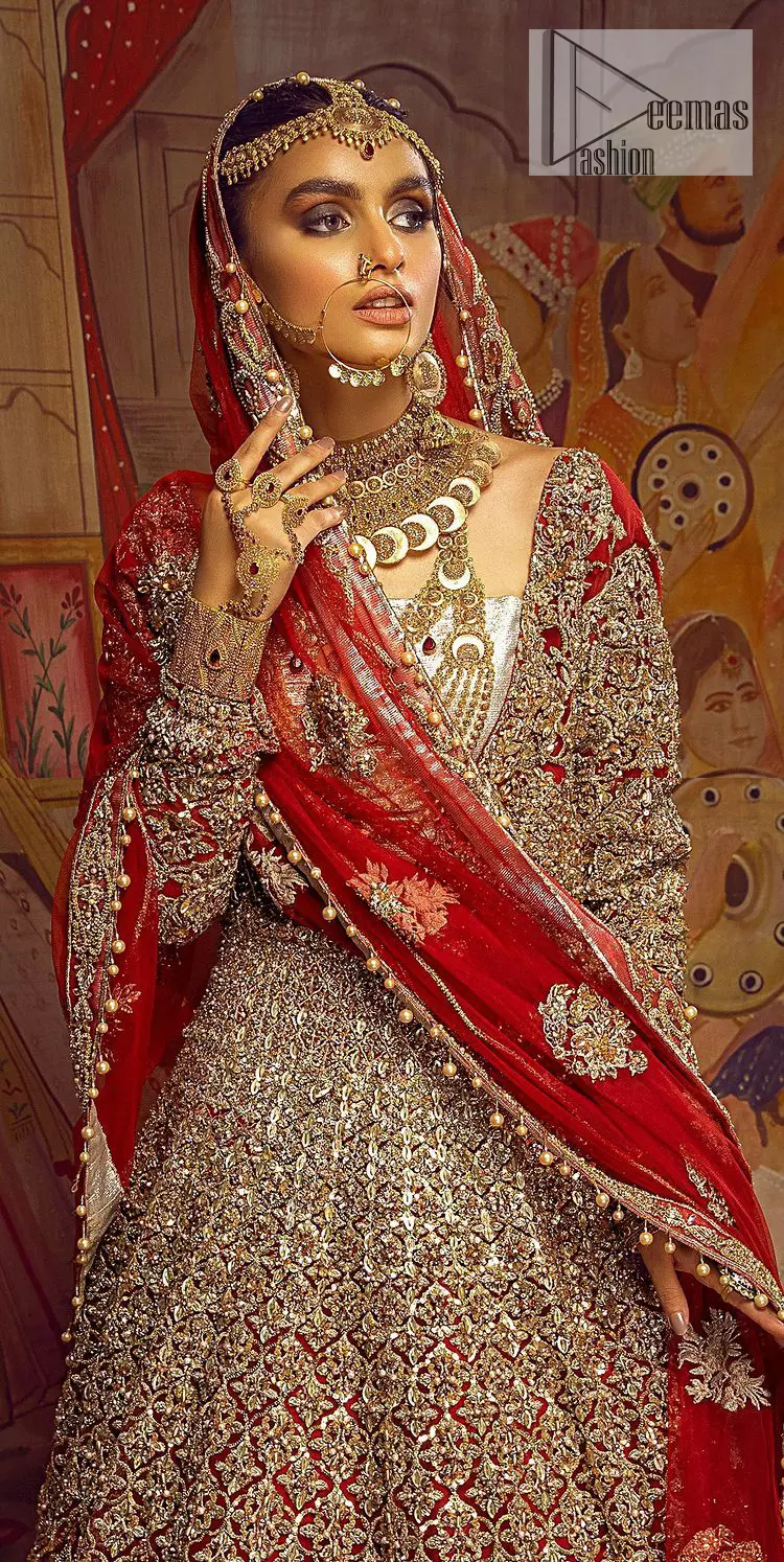 Encourage your reception day in this elegant yet classy deep red silhouette. Make your bridal look, in this deep red ensemble, heavenly adorned with golden embroidery highlighted with kora, dabka, zardozi,tilla, crystal, pearls and sequins. The heavily loaded embroidered border completes the look of the maxi. In addition to this, the V shape neckline along with full sleeves is such a graceful artistic look. It is paired up with this heavily loaded dupatta with intricately handcrafted borders, further enhanced with floral motifs and sequins spray all over to add a romantic and aesthetic look to this article.
