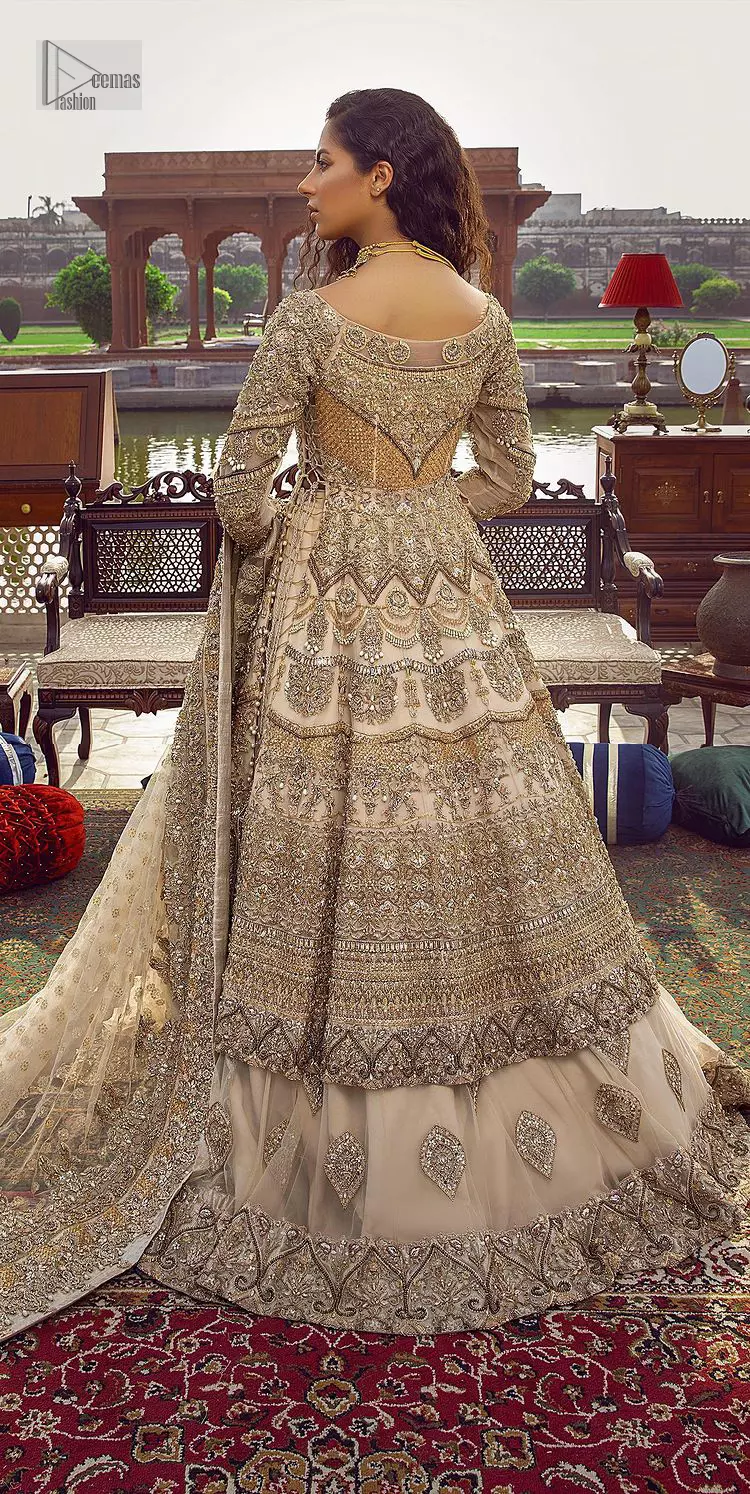Capturing the essence of modernity on your Nikah with this ivory article. DeemasFashion presents this frock which is intricate with hand embroidery that includes tilla, dabka, kora, Kundan, zardozi and magic of crystal. It is intensified with silver and gold embroidery to make your Qabool Hai moment more delightful and pleasant. Further, the boat shape neckline with three-quarter sleeves strengthens the beauty of the outfit. The following frock is systemized with a lehenga whose border is framed with heavy embroidery. The floral motifs also spread on the lehenga. Complete this outfit with a dupatta in the same colour which is ornamented with four-sided borders and sequins sprayed all over to capture the modern bride.