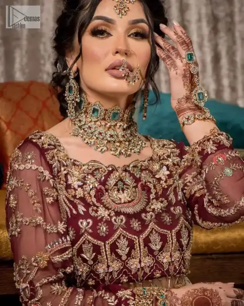 Take your style up a few notches in this elegant reception piece. A pure organza maroon fluffy lehnga is beautifully