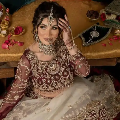 Take your style up a few notches in this elegant reception piece. A pure organza maroon fluffy lehnga is beautifully