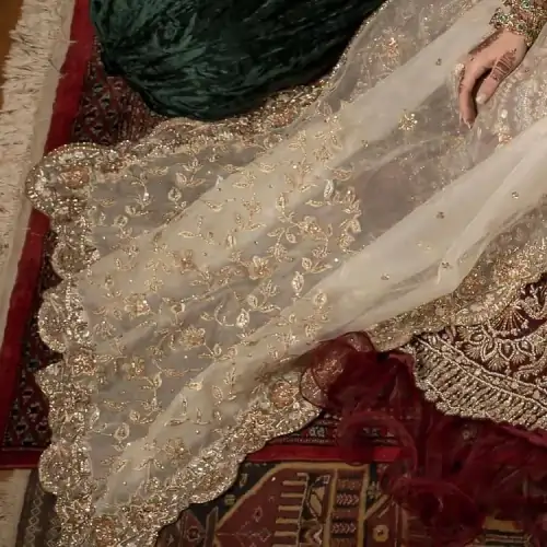 Take your style up a few notches in this elegant reception piece. A pure organza maroon fluffy lehnga is beautifully