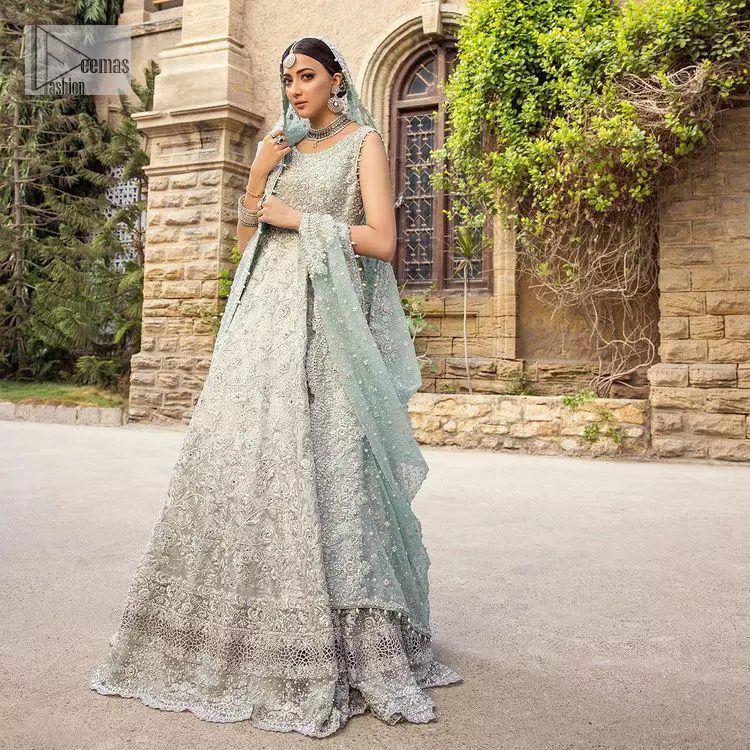For the love of blue! A raw silk pale blue maxi with a heavy border is beautifully embroidered in silver colour. The maxi is enhanced with tilla, dabka, kora, Kundan, Sitara and detailing of resham. The round shape neckline is also beautifully decorated with silver embroidery to enhance the sleeveless style of the following maxi. It is paired up with a scalloped dupatta which is ornamented with four-sided borders and sequins sprayed all over in the same colour leaving you at the start of the Nikah event.