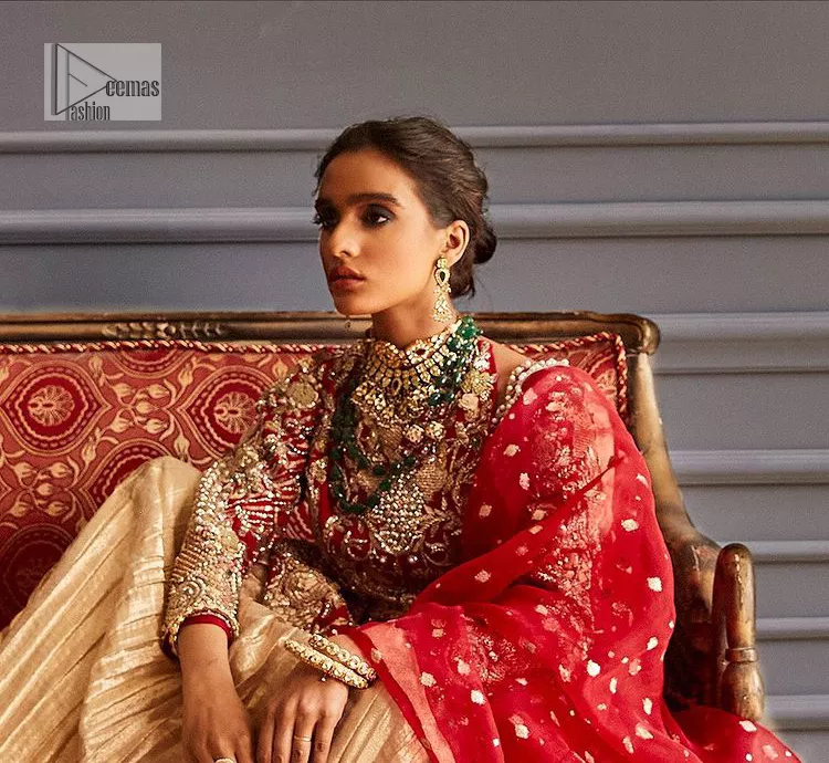 The magic of luxurious romantic outfits at your reception, giving out love and letting it come in. The Beautiful bright red short frock is adorned with classy golden embroidery and will look breathtaking on the traditional bride. The boat shape neckline makes this frock a glamorous choice to pair with the classy golden crushed lehenga. In addition to this, the following frock is enhanced with tilla, dabka, kora, Kundan and the real magic of zardozi. Crushed Lehenga paired with the Embellished frock enhances the overall Royal look of the outfit. The perfect stitching and crushed style make this Lehenga your first-ever priority. Complete this article with a scalloped dupatta that is embellished with four-sided borders and sequins sprayed all over.