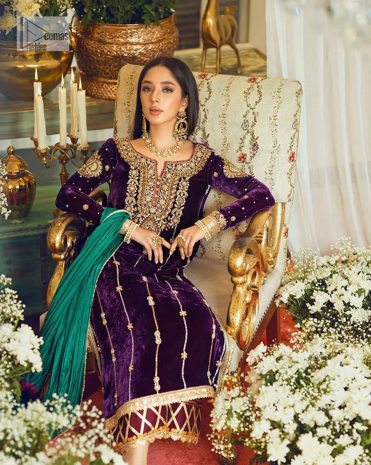 Dress yourself up in glamorous ensembles. DeemasFaashion presents this beautiful party outfit in plum colour. It is highlighted with golden embroidery which is further enhanced with tilla, dabka, kora, Kundan and the real magic of zardozi. The full sleeves are embellished with sequins spray and floral motifs. In addition to this, the embroidered neckline makes this outfit more pretty. It is paired with maroon trousers with beautiful and stunning borders to balance the article. Complete this article with a dupatta in green and plum colour to fulfil the aesthetic look. 