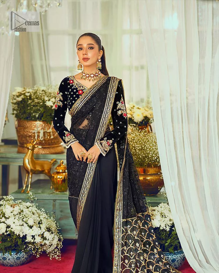 Black, is a reminder to love yourself. The navy blue blouse is augmented with elusive dabka and remarkable naqshi to highlight the grace and is further enhanced with tilla, dabka, koran and Kundan.  The V shape neckline of the following blouse is beautifully decorated with multiple colour embroidery. In addition to this, the heavy floral motifs also adorned the full sleeves to add more charm and beauty to this party wear. It is paired with a black saree to style you according to your choice. Complex work on the borders and the pallu makes it look even more gorgeous. This is a beautiful piece for a bridesmaid who has traditional taste.