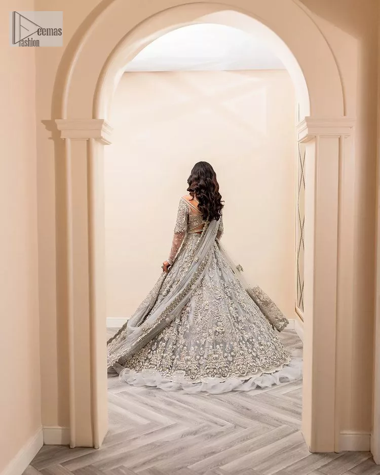 Enter the world of allurement with steel grey, a gorgeous go-to dress for nikah to make you look classy and fabulous at the same time! The delicate details of this gorgeous bridal dress are from exquisite patterns observed in silver embroidery which is prominent with tilla, dabka, kora, Kundan, Zardozi and the real magic of crystals. The house has V shape neckline to make this masterpiece a little romantic and classy. Further, full sleeves are fully designed with fantastic floral patterns spread all over. It is paired with a lehenga having frilled to complete the lavish look of this fully embellished nikah wear. Complete this article with a dupatta adorned with four-sided embellished borders and sequins sprayed all over.