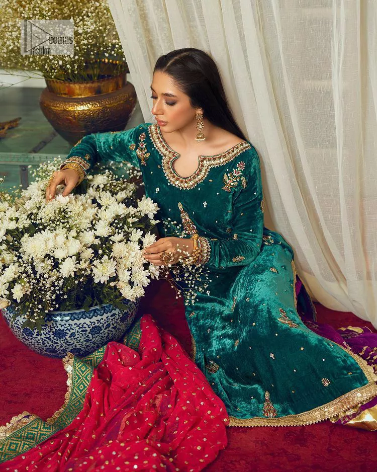 Brighten up your day with this beautiful ensemble. This long shirt style in a teal green colour is a perfect outfit that gives you a royal look on the festive occasion. The embroidered neckline and full sleeves make this outfit an epitome of beauty. Further, Embroidery work which enhances with tilla, dabka, kora, Kundan and lavish designs makes this outfit your priority for the day. It is paired with plum trousers which have finished edges to balance the overall look of the day. Complete this party wear with a dupatta in pink colour sparkling sequins spray all over. 