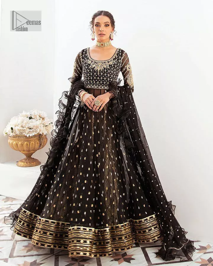 Let your outfit speak for the style tale itself! The frock, lehenga and dupatta combination is a breathtaking attire that comes in black colour. Traditional designs and hand-crafted embellishments on the frock which involves tilla, dabka, kora and Zardozi give a magnificent look to this perfectly. The beautiful light golden embroidery on full sleeves makes this article stunning and loving. It is paired with jamawar lehenga in the same colour to add some traditional look. Complete this party wear with a frilled dupatta sparkling with a sequin spray to make your day bright. 