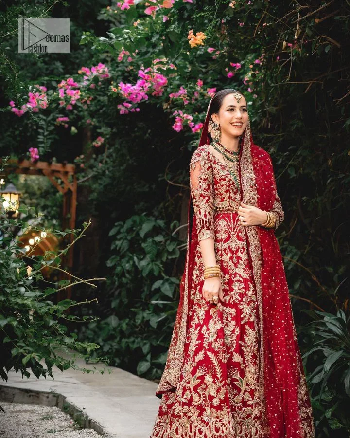 Classic deep red canvas with a bold twist of the pattern!  Bridal choli in the deep red shade is a beautiful attire to wear on the big day to have an elegant and classy look. This beautiful choli is heavily embellished with crystals, pearls, dabka,tilla, kora, Kundan, stones, and Zardozi giving a magnificent touch to the lehenga choli. The round neckline of the attractive blouse makes an outfit look more sophisticated. Further, the beautiful floral patterns on three-quarter sleeves make this outfit a must-have for your day. It is paired with a heavily embellished lehenga and is a stylish choice for the gorgeous Bride. Complete this romantic article with a dupatta framed with four-sided embellished borders and sequins sprayed all over.