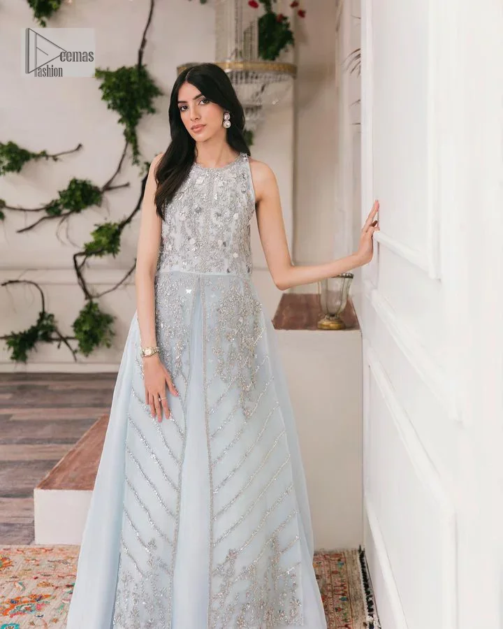 Shine and sparkle in this ice-blue nikah outfit! A mesmerizing long shirt stuns in a beautifully handcrafted silver embroidery enshrined with tilla,dabka, kora, Kundan, Zardozi, stones and the real magic of crystals. The jewel neckline has detailed intricate floral patterns. The sleeveless style of this ice blue front open shirt is the true essence of DeemasFashion. It is organized with a plain lehenga in the same colour to complete your stylish appearance.