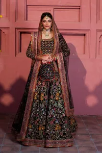 Make your superb days bright and bold! A jet black blouse with floral branches, peacock motifs and Mughal-inspired embellishments with dabka, naqshi, cut dana, Resham, Swarovski, Zardozi, tilla and Kundan. It is supported with a round neckline and full sleeves to make this masterpiece a traditional look. The lehenga has an embellished border around its flare that is complemented and decorated with multiple colour embroidery. It is paired with an organza dupatta in the same colour with a sequin-sprayed surface and intricately embellished borders on all sides.