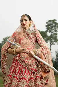 It is arranged with flared lehenga in the same color that ensures both comfort and sophistication as you exchange vows. The classic peach color dupatta reflects the solemnity of the Nikah, while subtle embellishments add a touch of elegance.