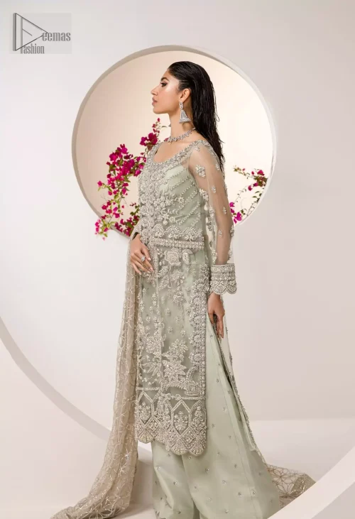 The round neckline and full sleeves craft a graceful, timeless silhouette, while the scalloped hem lends a touch of whimsy.