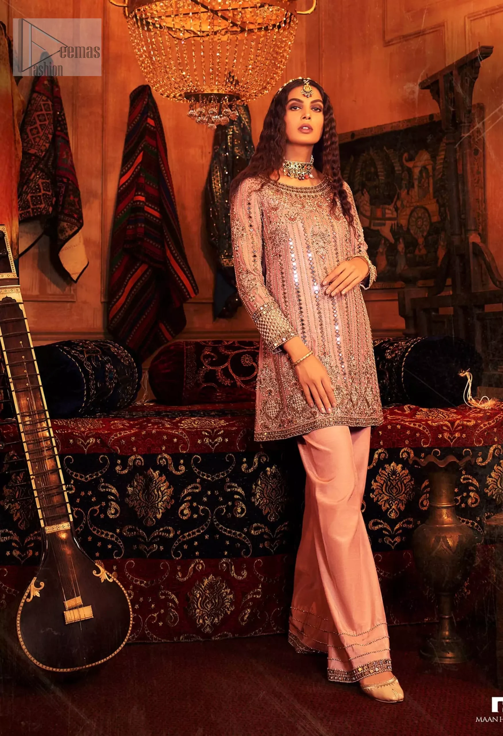 The soft salmon pink shade radiates a sense of femininity, while antique embroidery and mirror work weaves a tale of tradition and grace. The stylish boat-shaped neckline and full sleeves create a sophisticated silhouette. Salmon Pink Short Shirt - Palazzo Pants