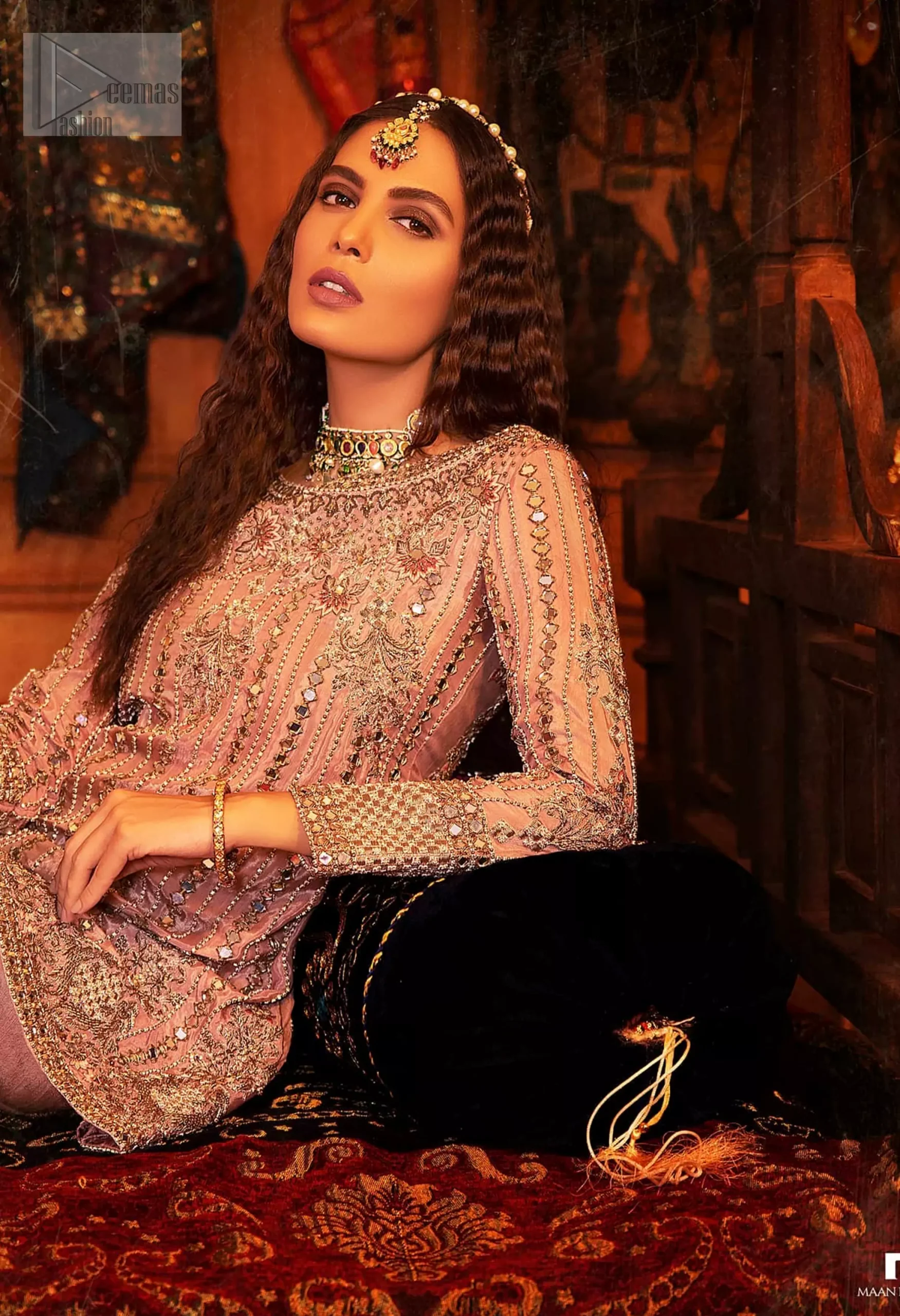 The soft salmon pink shade radiates a sense of femininity, while antique embroidery and mirror work weaves a tale of tradition and grace.