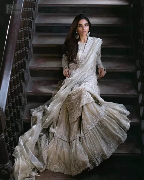 Dynamic three-quarter angle of the beige zari net Nikkah outfit in motion.