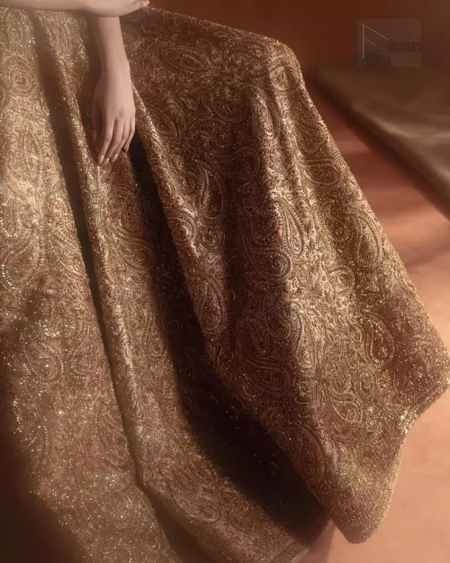 Bronze organza dupatta draped with scattered tiny floral motifs.