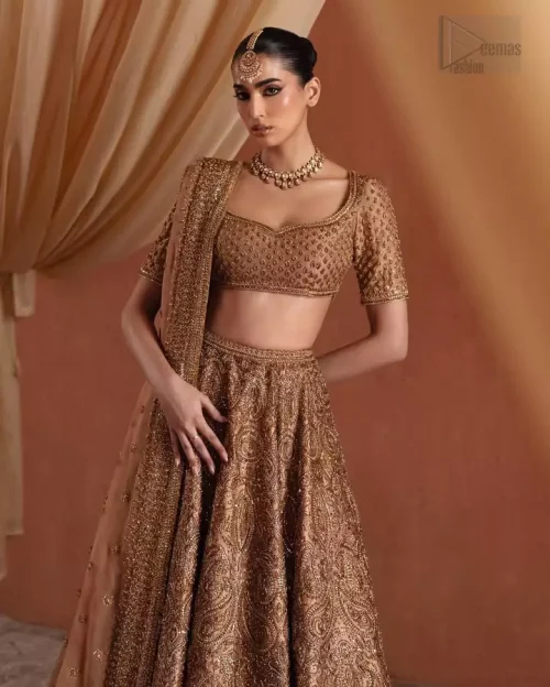 Bride wearing bronze raw silk lehenga and half-sleeve sweetheart neckline blouse for wedding reception.