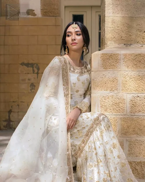 Dynamic side angle view of ivory raw silk short shirt and organza gharara ensemble.