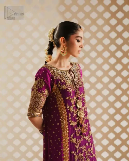 Round neckline with teal appliqué and golden zardozi embroidery on magenta shirt.