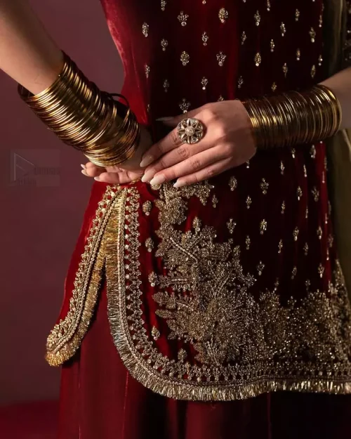 Premium maroon velvet fabric texture with scattered tiny motifs.
