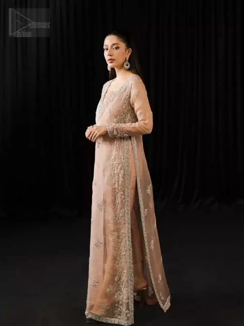 Angled view of pale peach floor-length shirt and cigarette pants showing fluid drape.