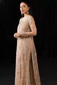 Full sleeves and embroidered side slits on pale peach floor-length shirt.