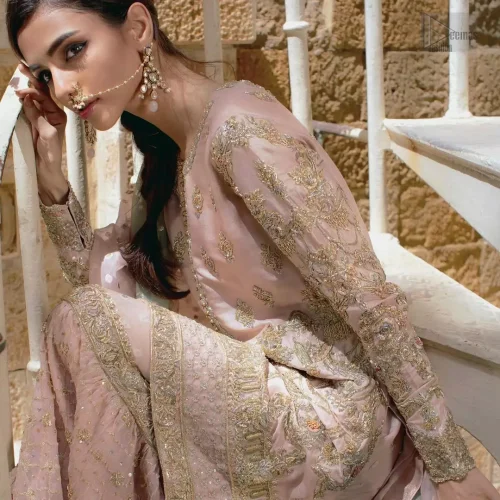 Dynamic action view of pastel pink Nikkah ensemble with two-tone dupatta.