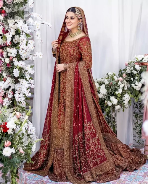 Angled action shot of red organza long shirt and farshi lehenga ensemble in motion.