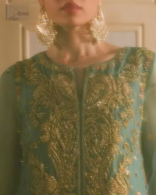 Round neckline with multi-color appliqué and golden embroidery on sea green shirt.